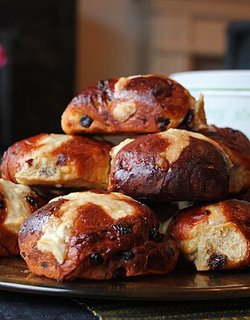 A plate stacked with freshly baked hot cross buns