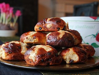 A plate stacked with freshly baked hot cross buns